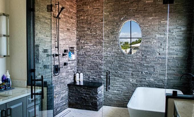 Large Walk In Shower with a Frameless Glass Enclosure and Stacked Stone used on the walls